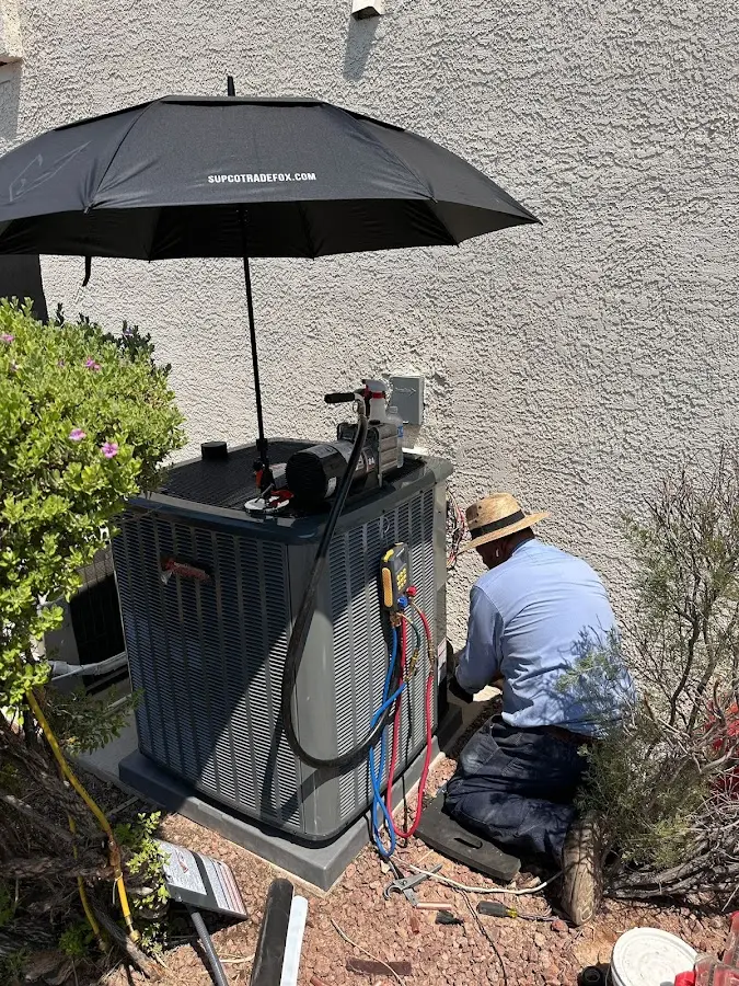 HVAC technician performing outdoor AC maintenance in Chaparral