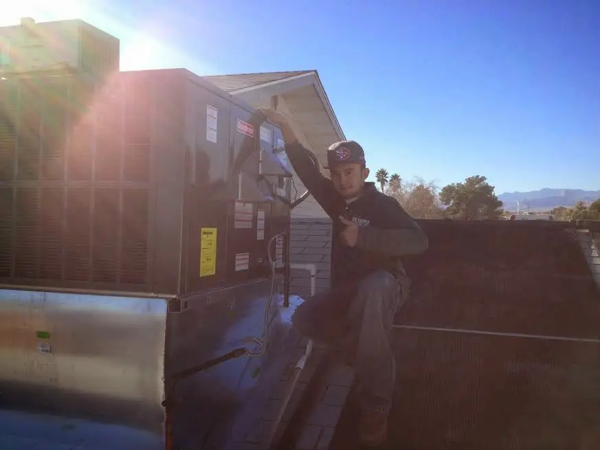 HVAC technician performing Air Duct Cleaning on a rooftop unit in Chaparral
